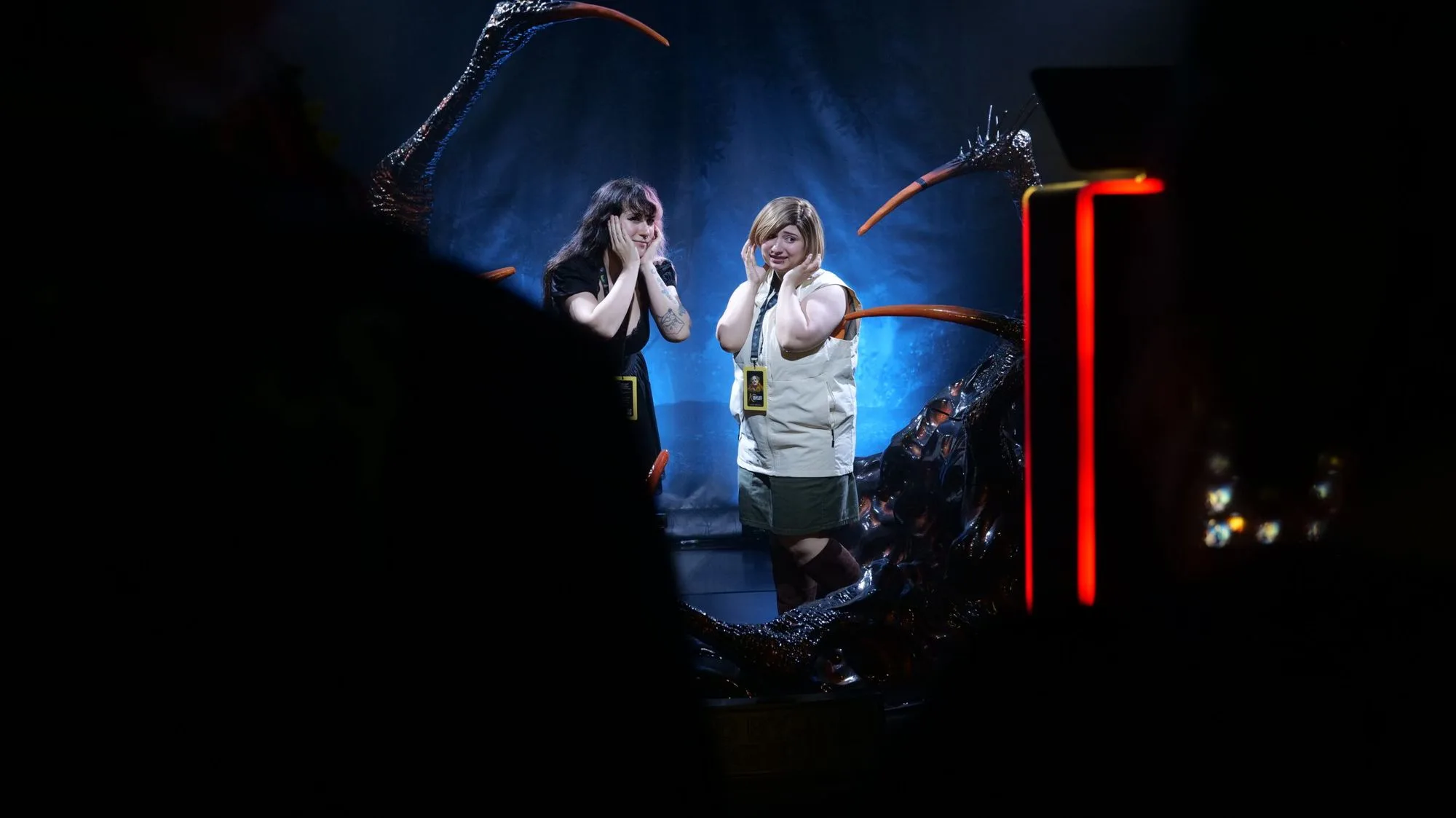 Two cosplayers standing inside the claws